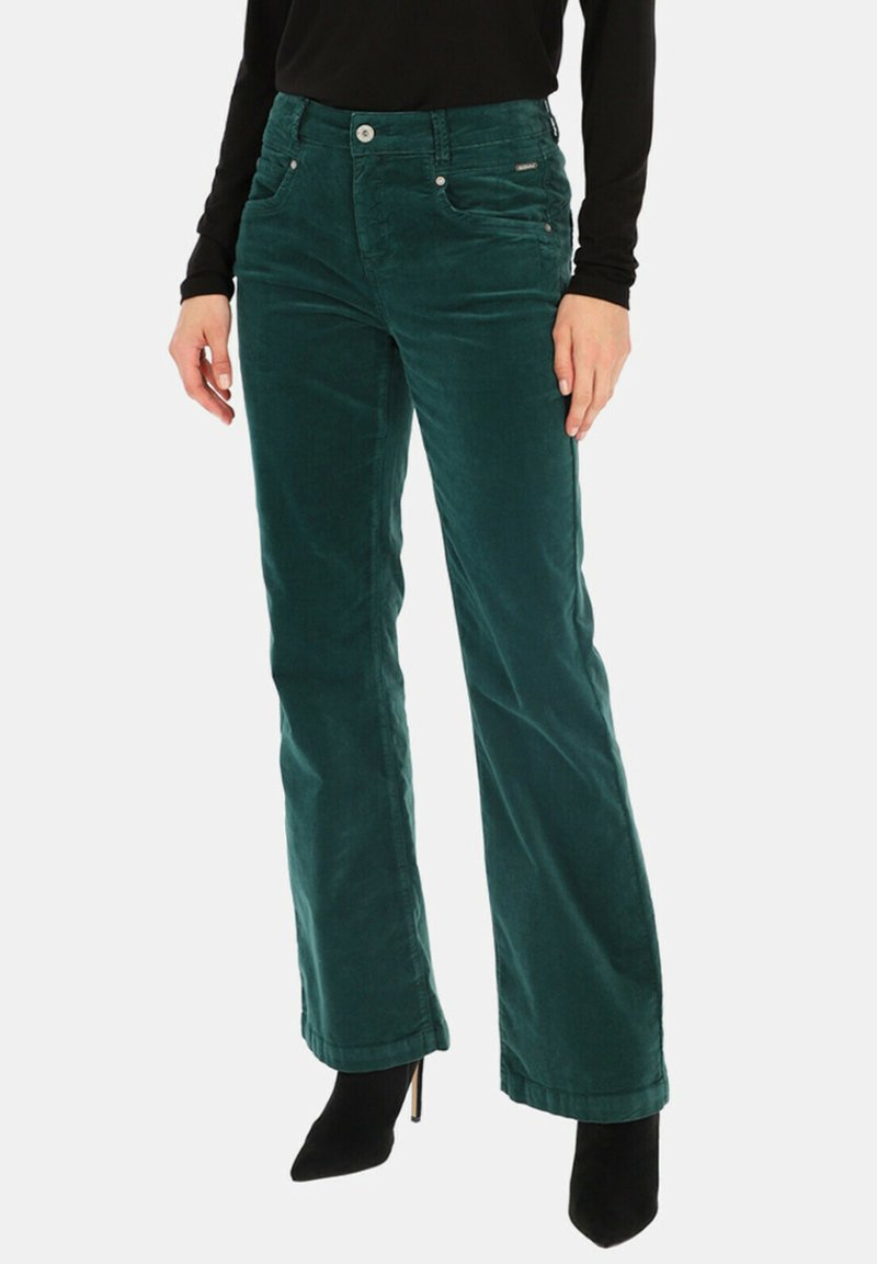 Zielone spodnie sztruksowe z dopasowanym stanem i prostymi nogawkami. Posiadają przednie kieszenie oraz gładką fakturę. Połączone z czarnymi szpilkami.