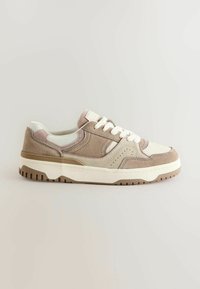 Beige og tan sneakers i ruskind og læder, med afrundet tå, hvide snørebånd og en tekstureret ydersål. Klassisk, sporty design med detaljer.