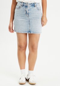 Light blue denim skirt with a straight cut, front button closure, and belt loops. Features two front pockets and a slight frayed hem.