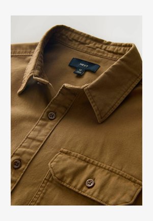 Camicia marrone a bottoni realizzata in tessuto texturizzato, con colletto, taschino frontale e due bottoni marroni. Etichetta del marchio visibile all'interno del colletto.