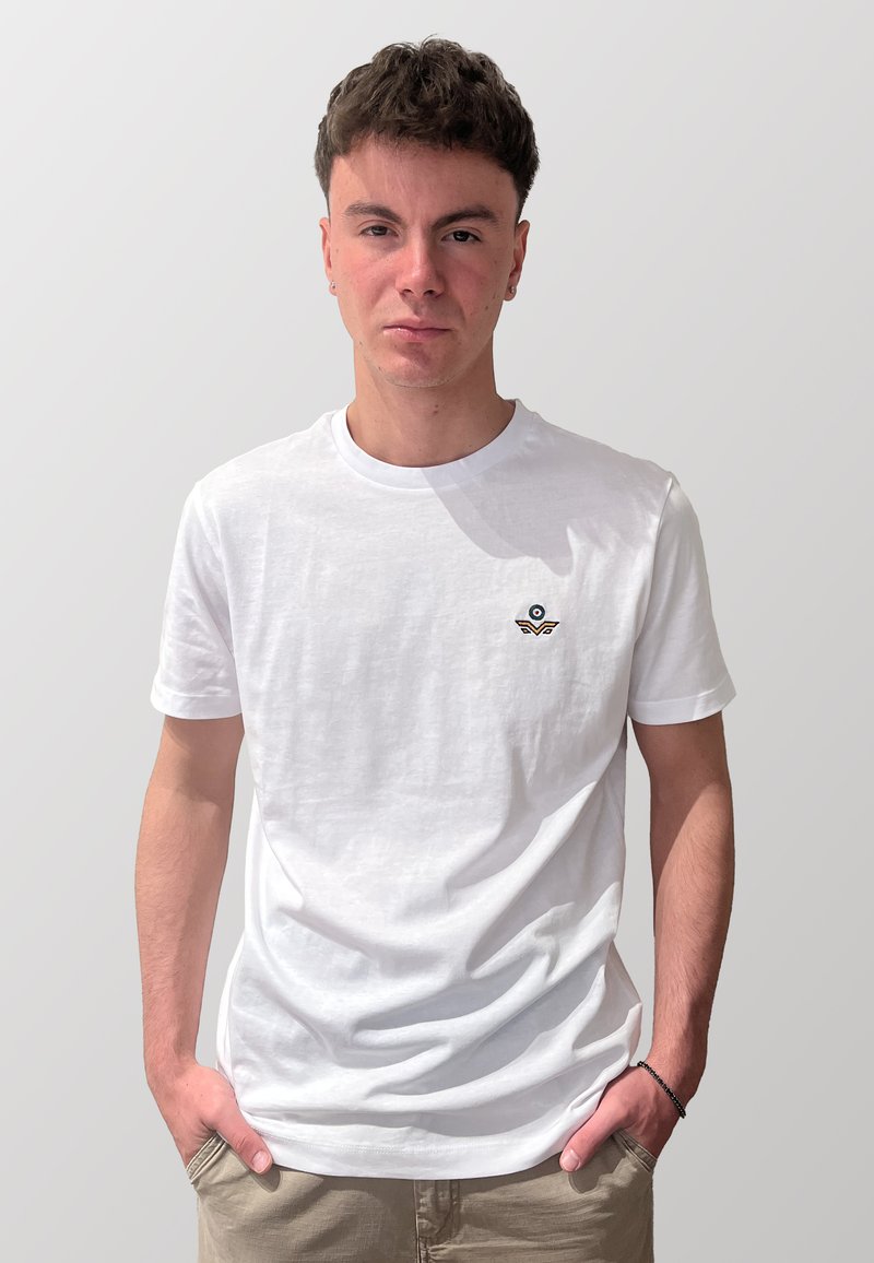 T-shirt in cotone bianco con un piccolo logo ricamato in blu e marrone. Design semplice con collo a giro e maniche corte. Tessuto morbido.