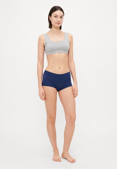 Gray cotton sports bra paired with navy blue stretchy shorts. The bra features wide straps and a simple, seamless design.