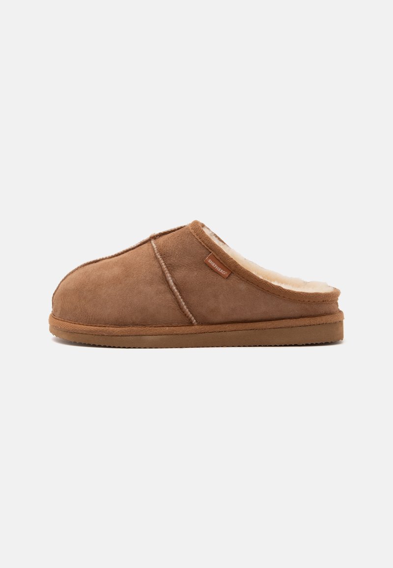 Chausson marron en daim, facile à enfiler, avec doublure en polaire couleur crème et semelle en caoutchouc, étiquette latérale marquée "Shepherd" visible.