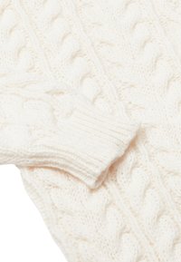 Helle, gestrickte Pullover in Cremefarbe mit einem Zopfmuster, gerippten Bündchen und weichem, strukturiertem Material. Keine sichtbaren Etiketten oder Logos.