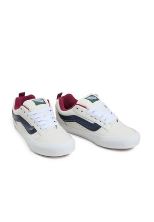 Weiße Low-Top-Sneaker mit navyblauen Streifen, burgunderfarbenen Akzenten und weißen Schnürsenkeln. Verfügt über strukturiertes Leder und eine Gummisohle.