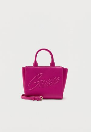 Bright pink Guess handbag with dual top handles, detachable shoulder strap, and embossed brand name on front against plain background.
