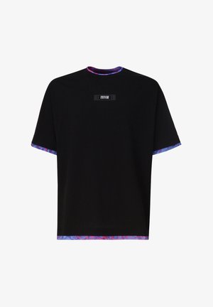 T-shirt noir à manches courtes avec bordures violettes et rouges sur le col, les manches et l'ourlet, arborant un petit logo rectangulaire Versace Jeans Couture sur la poitrine.