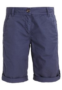Tummansiniset shortsit sileällä pinnalla, etunapituksella ja käännetyillä lahkeilla. Kyljissä taskut ja huomaamatonta ompelutyyliä.