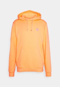 Orange huva sweatshirt i mjukt tyg, med en känguruficka och en liten lila Adidas-logotyp på bröstet.