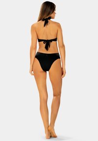 Czarny bikini składający się z topu bandeau z zapięciem z tyłu oraz wysokich majtek, oba wykonane z gładkiego, jednolitego materiału.