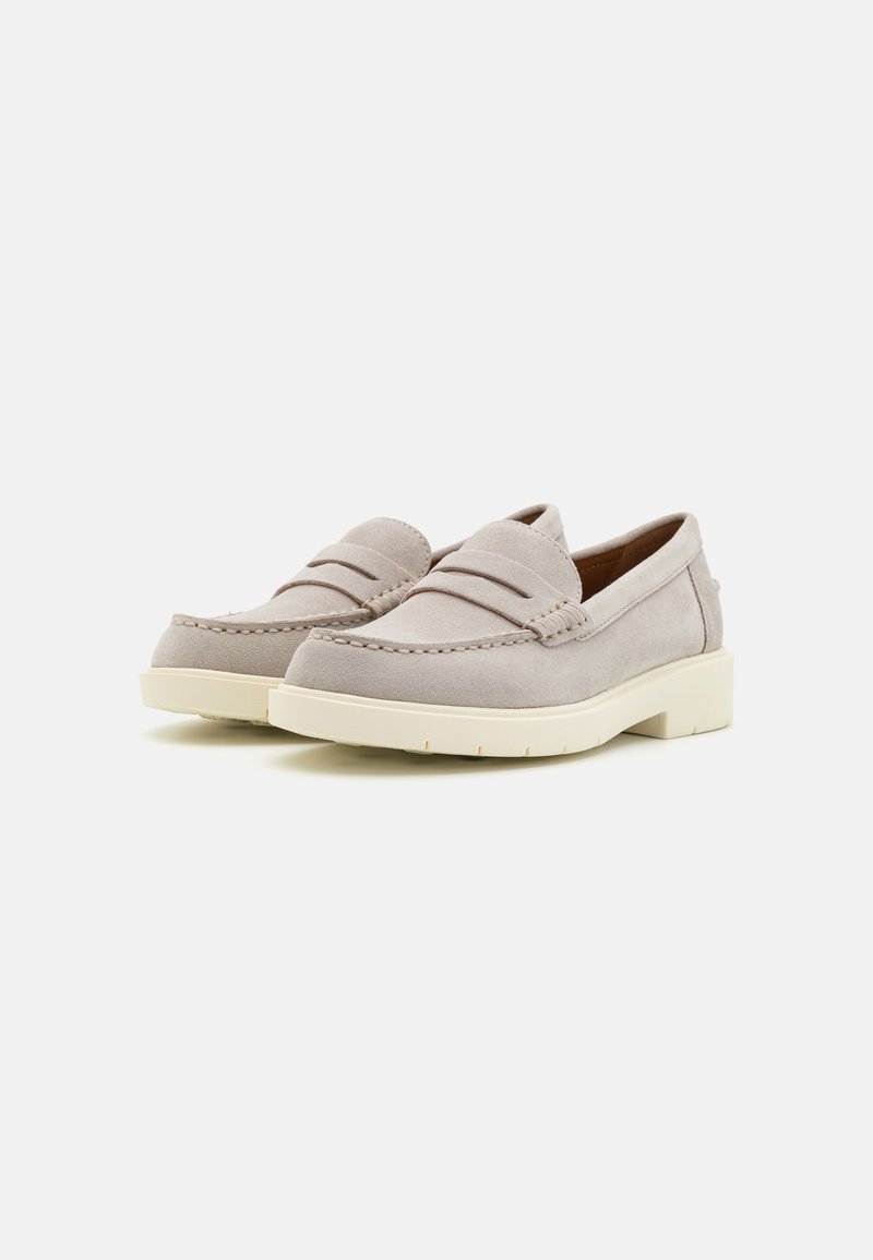 Mocasines de ante beige con doble pliegue delantero, acentos cosidos y suela de goma crema, con un tacón bajo y diseño sin cordones.