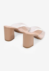 Sandalias transparentes con tacón cuadrado, con una suave plantilla en tono nude, que presentan tiras transparentes y un diseño de tacón robusto.