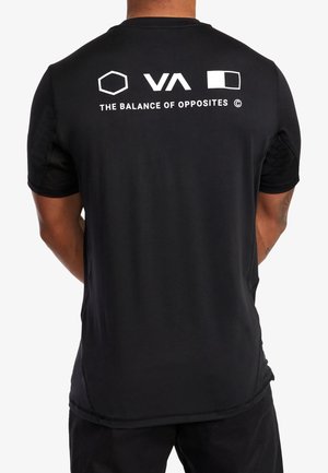 Czarna koszulka z krótkim rękawem z białymi geometrycznymi logo i napisem "THE BALANCE OF OPPOSITES" na górnej części pleców, noszona przez osobę zwróconą plecami.