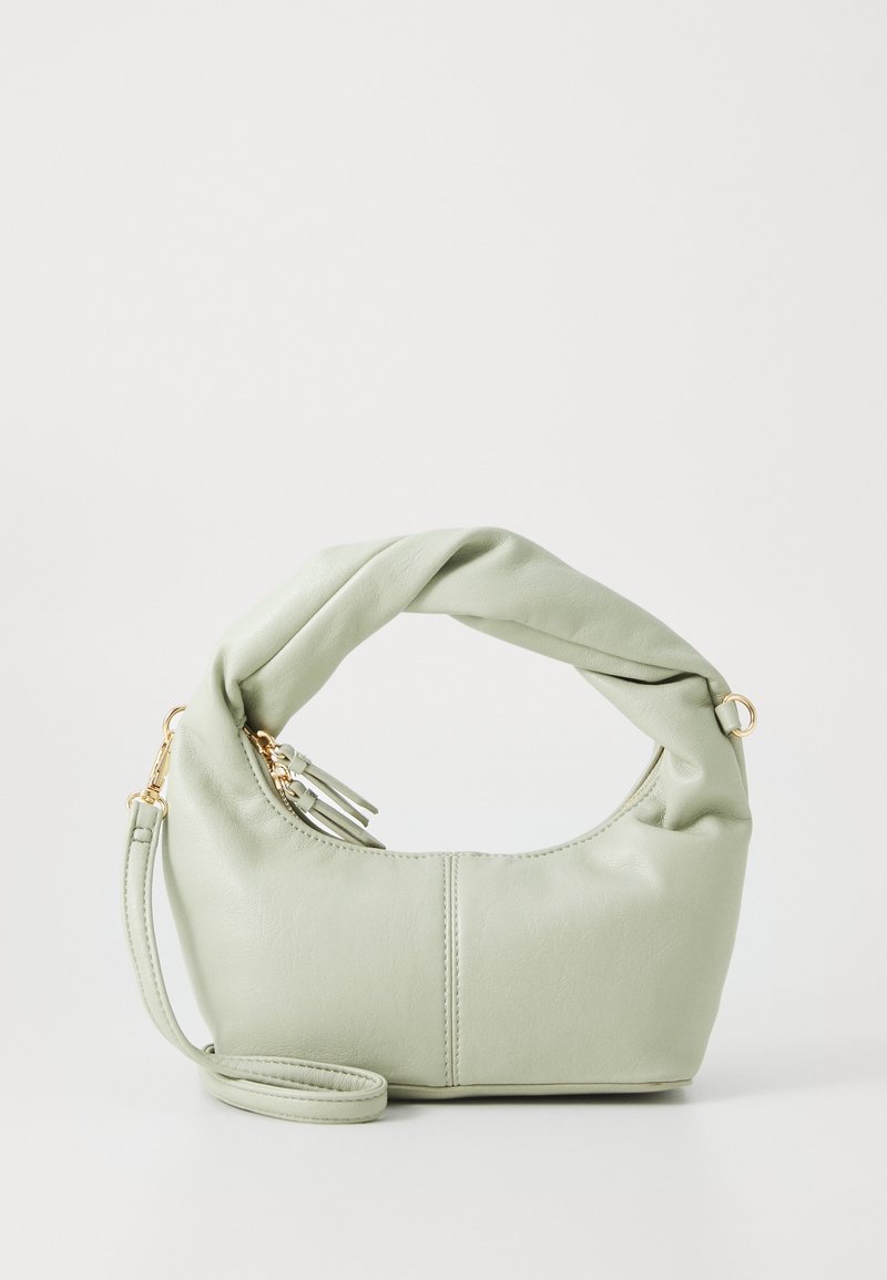 Sac à main en cuir souple vert clair avec poignée torsadée, fermeture éclair dorée et sangle de poignet amovible sur fond blanc.