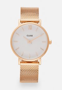 Cadran de montre blanc rond avec des index horaires dor�és et le texte 'CLUSE'. Bracelet en maille dorée. Design minimaliste, finition métallique lisse, texture élégante.