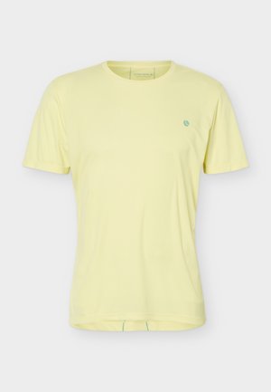 Light yellow short-sleeve crew neck t-shirt with small blue circular logo on left chest, displayed on plain background.