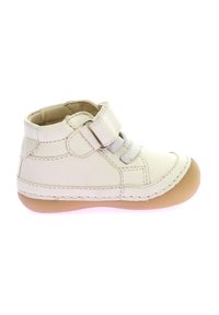 Zapatilla alta de cuero blanco con suela de goma beige, que cuenta con una correa de velcro y detalles de cordones. Textura suave con costuras cosidas y un diseño minimalista.