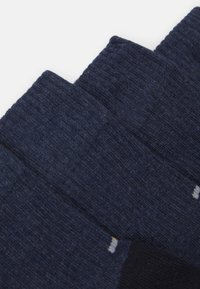 Calze blu navy con un tessuto testurizzato, parte superiore a costine e piccoli punti in contrasto bianchi e gialli.