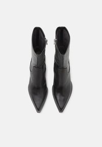 Μαύρες δερμάτινες μπότες μέχρι τον αστράγαλο με μυτερή μύτη, λεία υφή και πλαϊνούς φερμουάρ. Διαθέτουν κομψό σχέδιο και διακριτική ραφή.