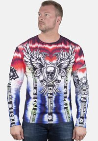 Langarmshirt mit einem rot-weiß-blauen Farbverlauf. Die Grafiken beinhalten Köpfe, Flügel und Schlangen mit schwarzer Schrift auf den Ärmeln.