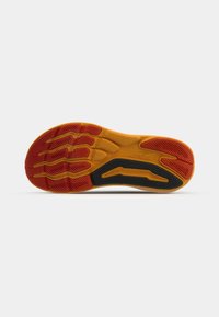 Schuhsohle mit strukturiertem Design in Gelb, Rot und Schwarz; enthält Flexrillen und ein gemustertes Grip-Detail für bessere Traktion.