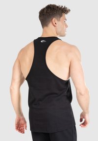 Czarny top na ramiączkach z plecami typu racerback, wykonany z bawełny. Wyróżniające się białe logo na górnej części pleców. Gładka faktura, dopasowany krój.