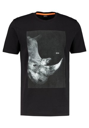 T-shirt en coton noir avec un grand motif monochrome de rhinocéros sur le devant. Col rond avec un accent orange contrastant à l'intérieur du col.