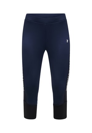 Mørkeblå cropped sportsleggings med sorte ankelmanchetter og hvidt logo på venstre lår, tekst delvist synlig på sidepanelerne.