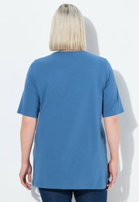 T-shirt blu a maniche corte realizzato in tessuto morbido, con scollo rotondo e vestibilità rilassata, con un taglio dritto sull'orlo e senza motivi visibili.