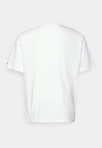 Camiseta de algodón blanca con mangas cortas, cuello redondo y detalles de costura sutiles. Textura suave y corte relajado, sin patrones o gráficos visibles.