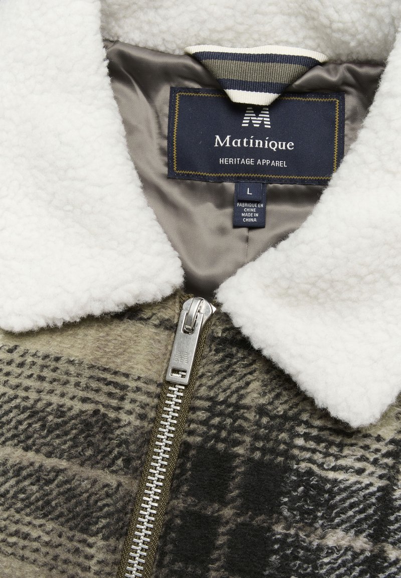 Braun-schwarz kariertes Jackett mit weißem Fleece-Kragen, silbernem Reißverschluss und navyfarbenem Innenetikett mit der Aufschrift "Matinique", Größe L. Strukturierter Wollstoff.