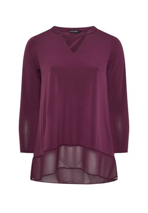 Lilla langærmet top med V-hals, der har et lagdelt design med en gennemsigtig nederste søm og en glat, let stofstruktur.