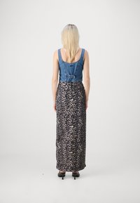 Vestido con corsé de mezclilla, parte superior azul y falda de estampado animal; cuenta con una cintura ajustada, espalda en forma de espátula y dobladillo inferior fluido con estampado de leopardo.
