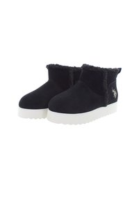 Schwarze Wildleder-Stiefeletten mit dicken weißen Sohlen, Schaffellbesatz und kleinem gesticktem Logo an der Seite.