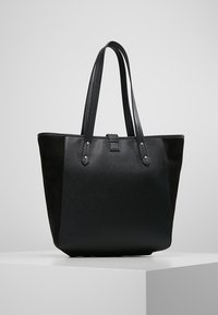 Czarna torba na ramię z gładkiej i teksturowanej skóry, z dwiema solidnymi uchwytami i zapięciem na klamrę. Prosty design z minimalną ilością metalowych akcentów.