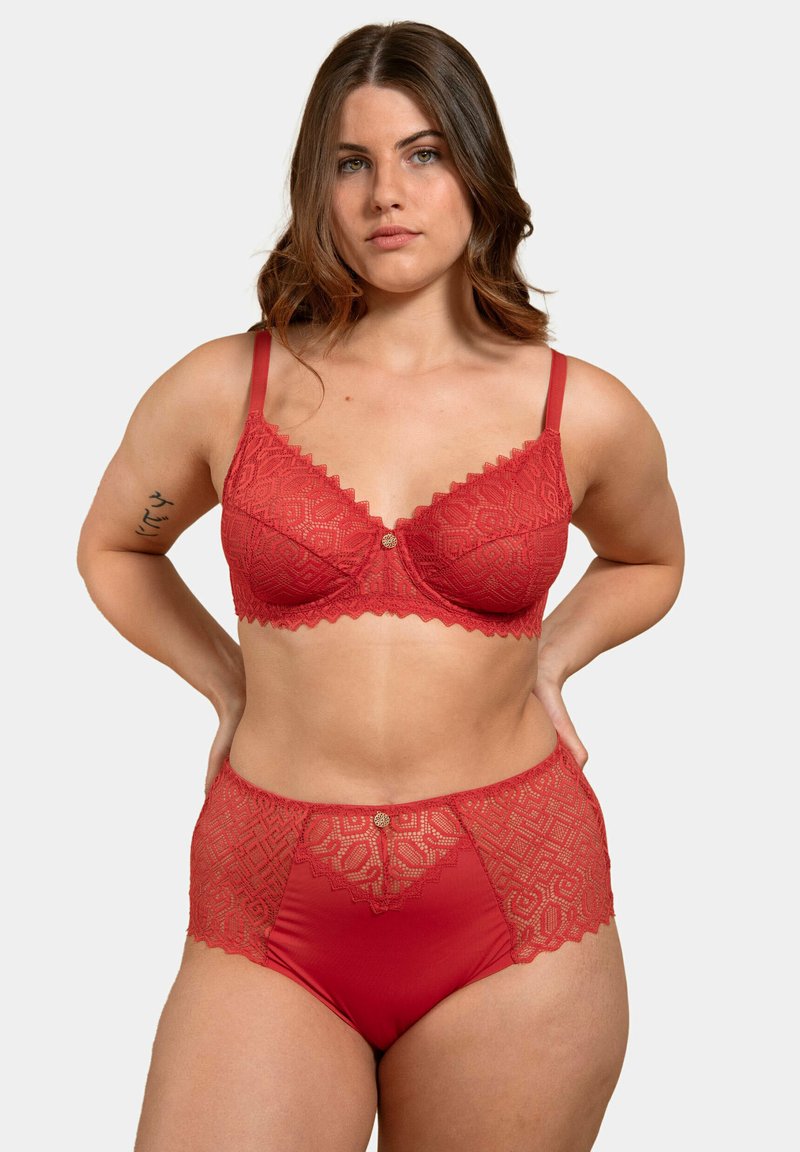 Ensemble de soutien-gorge en dentelle rouge et de culottes taille haute avec des bords festonnés et des motifs géométriques, comportant un bouton décoratif au centre.
