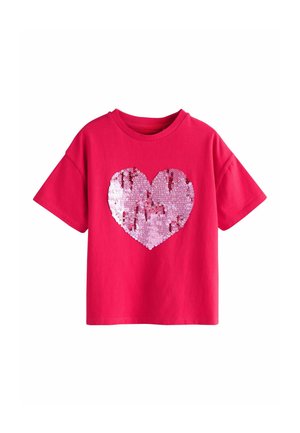 Red cotton t-shirt featuring a large pink sequin heart design. Short sleeves and a crew neck, with a smooth, textured sequin surface.