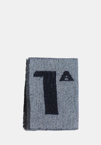 Sciarpa lavorata a maglia grigia con un prominente numero '7' di colore blu scuro e un accento triangolare. La texture sembra morbida e leggermente pelosa.