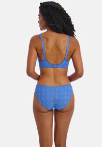 Set di bikini blu in pizzo con un motivo geometrico testurizzato, spalline regolabili e chiusura con gancio sul retro del top.