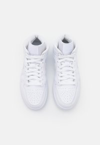 Paire de baskets montantes blanches propres avec des lacets, vues de dessus sur un fond blanc uni.