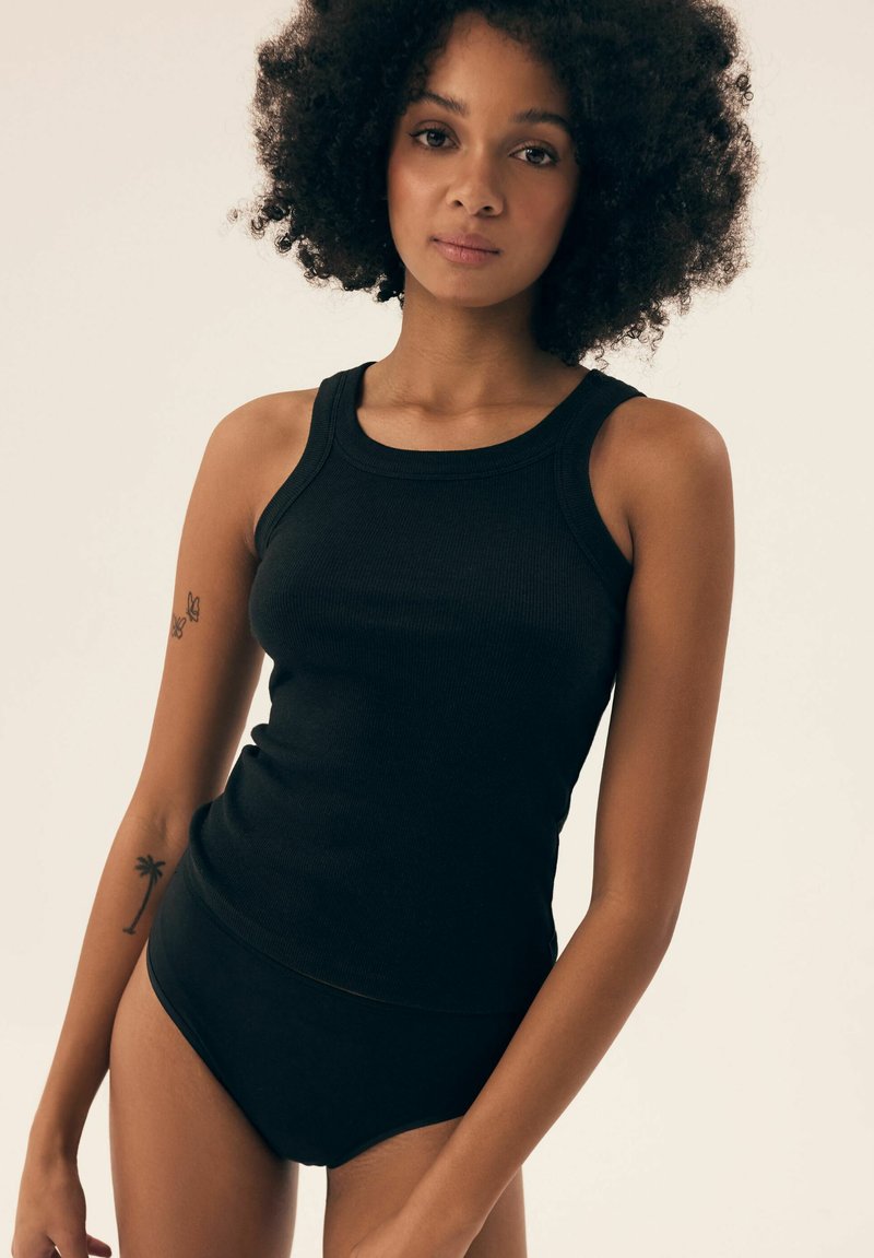 Black ribbed tank top with a rounded neckline, paired with high-waisted black briefs. Fabric appears smooth and fitted.
