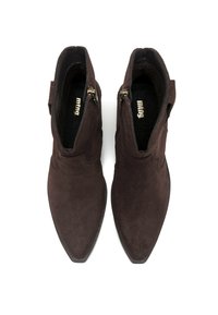 Un paio di stivaletti in suede marrone scuro, con punta appuntita e cerniere laterali, visti dall'alto su uno sfondo bianco.