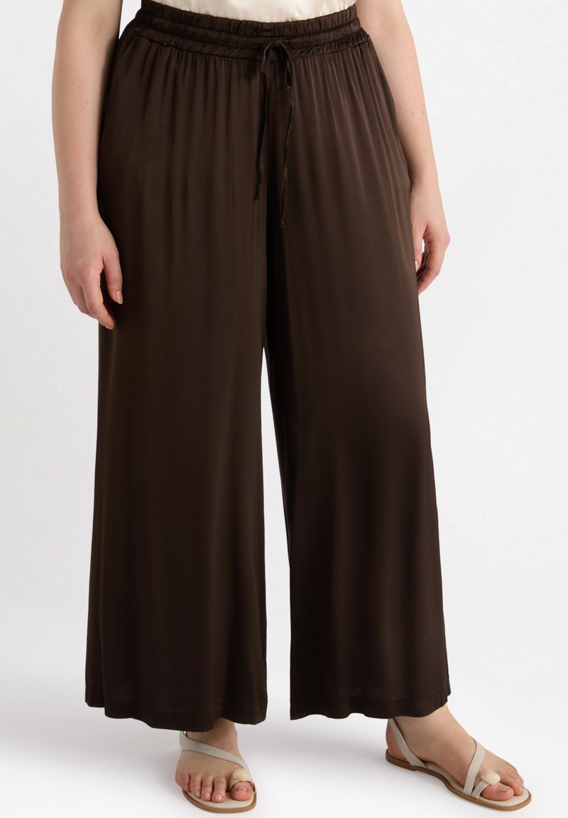 Pantalons marron à jambes larges avec taille élastique et cordon de serrage. Fabriqués en tissu doux, avec une texture lisse et une coupe décontractée.
