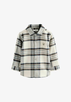 Pehmeast kangast ruuduline nööpidega särk, millel on kreemikas alus värv tumesiniste ja pruuni toonides ruudumustritega ning väikese karulogi rinnal.