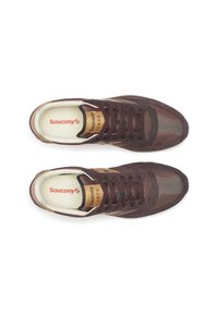 Un paio di sneakers brown Saucony Jazz con lacci, viste dall'alto su uno sfondo bianco, che mostrano il logo sulla soletta interna e sulla linguetta.