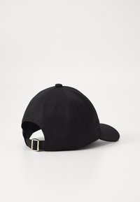 Căciulă de baseball din bumbac negru, cu vizieră curbă, curea reglabilă în spate și cusături contrastante pe coroană. Textură netedă, fără modele.
