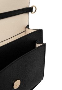 Portafoglio nero texturizzato con interno beige, dotato di un pulsante a pressione dorato e diversi scomparti per carte. Design compatto con spazio di archiviazione organizzato.