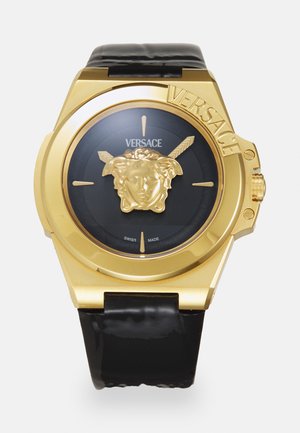 Gold-tone watch featuring a black dial, central Medusa emblem, and sleek black leather strap. Markings include "Swiss Made" and "Versace."