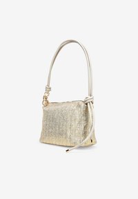 Bolso tejido de metal dorado con un mango de cuero suave, que presenta un diseño anudado. El bolso tiene forma rectangular y cierre con cremallera.