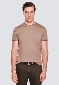 Brązowa koszulka z krótkim rękawem wykonana z miękkiego, lekkiego materiału. Posiada okrągły dekolt z kontrastową ciemnobrązową lamówką.